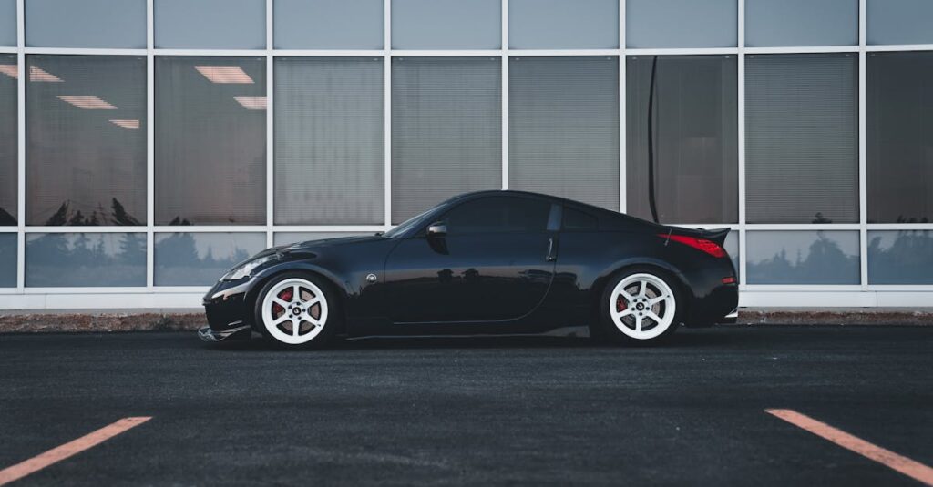 A stylish black car parked in front of a modern urban building.